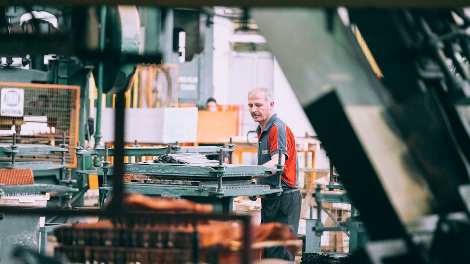 An operator running industrial machinery on a factory floor