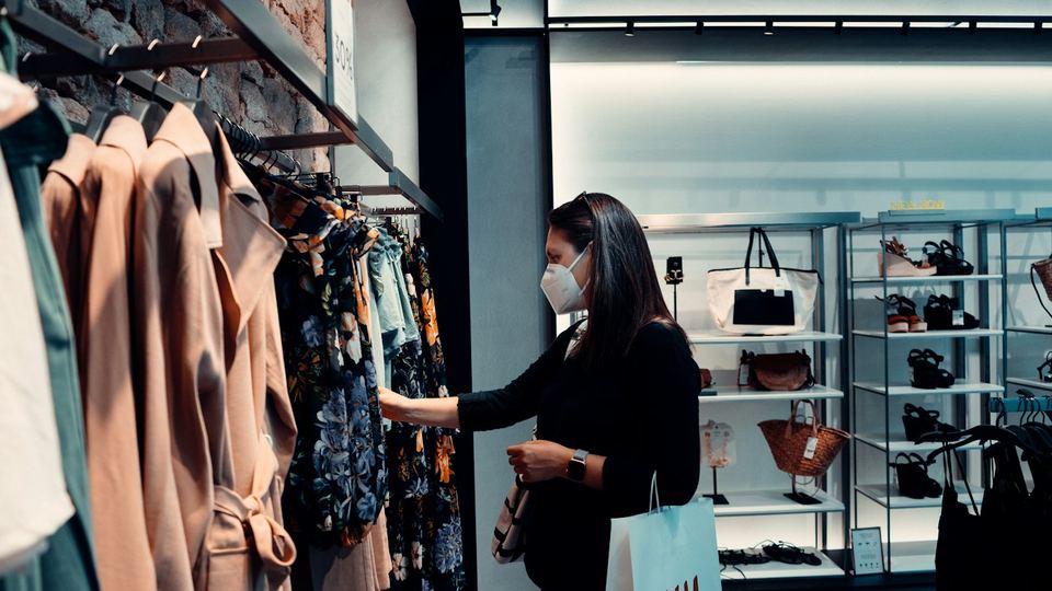 A shopper browsing clothing rails in a modern store